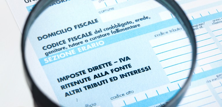 F24 for the tax return in Italy with magnifying glass.